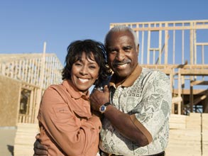 Middle aged couple embracing in front of a construction site