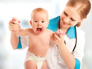 Wide eyed and wide mouthed infant being stood up by a doctor.
